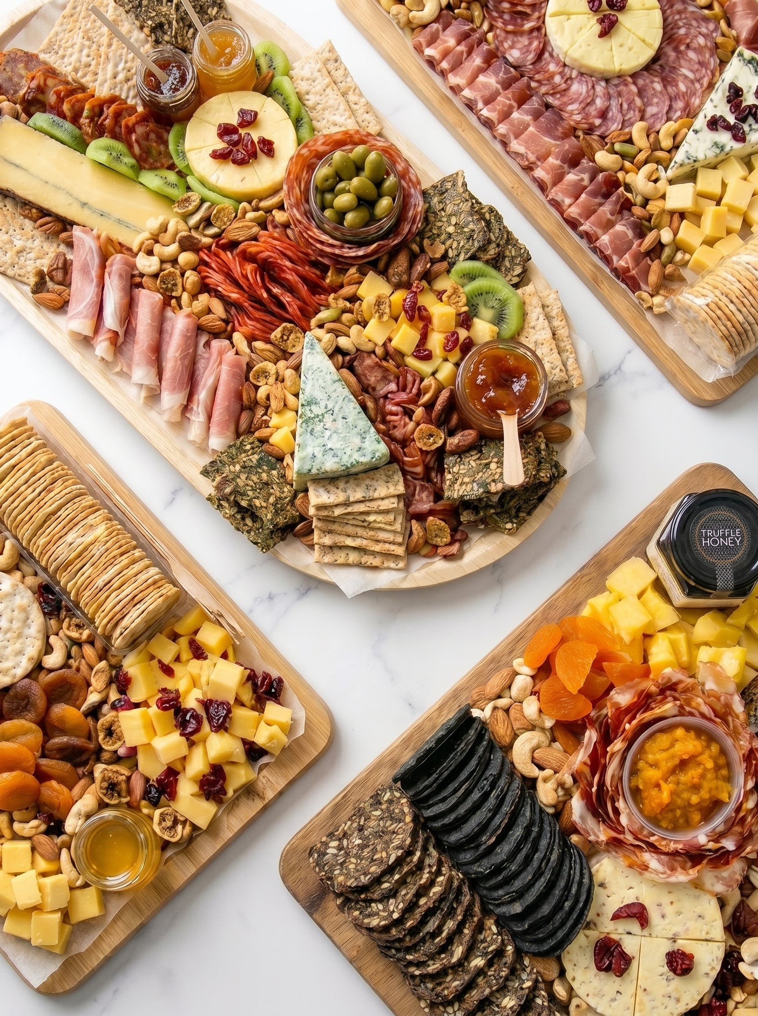 Four charcuterie boards and cheese platters on a white marble table — meat and cheese platter spread by The Smokehouse Collective Singapore